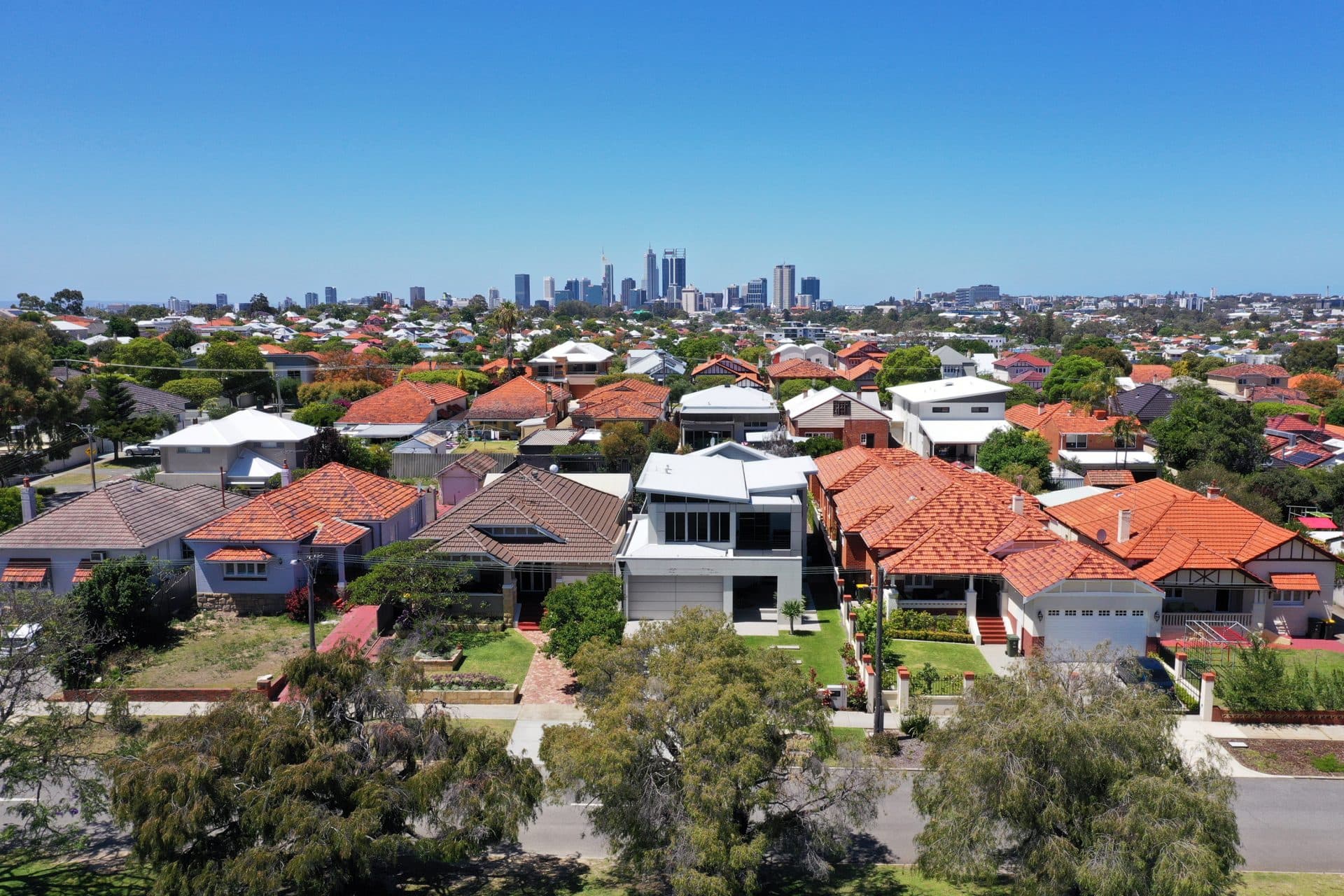 Suburban neighborhood with city skyline in the distance.