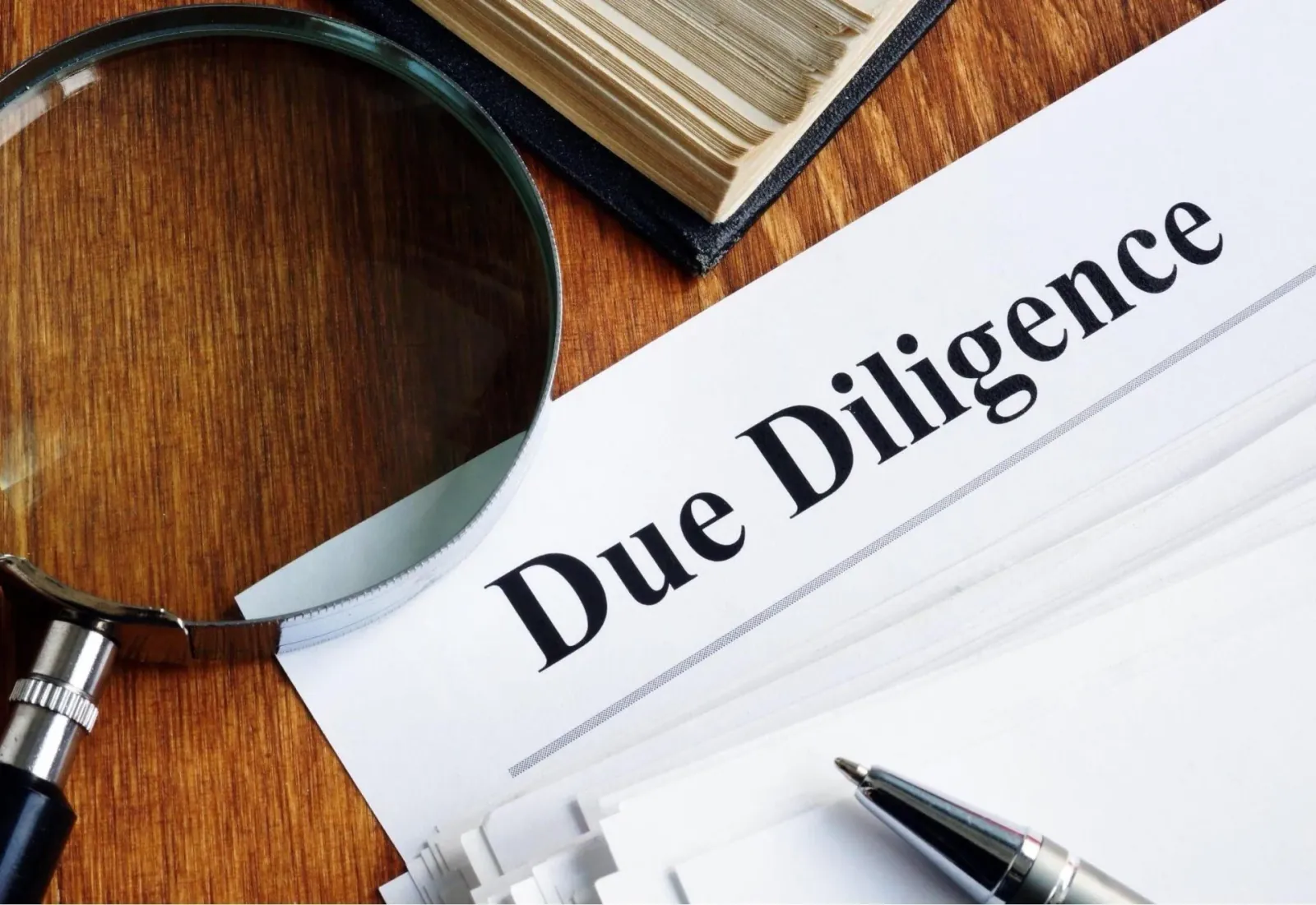 Due Diligence document with magnifying glass and pen