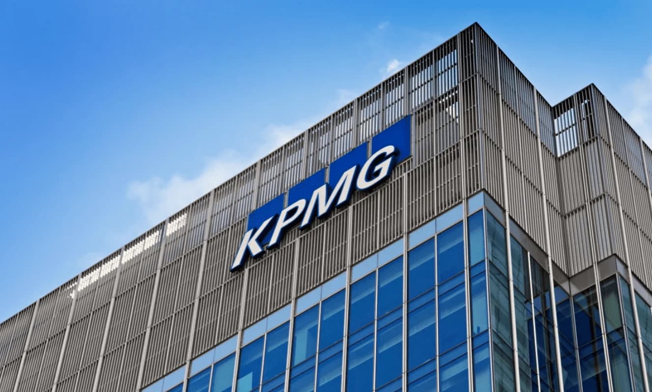 KPMG building exterior with blue logo on a clear day.