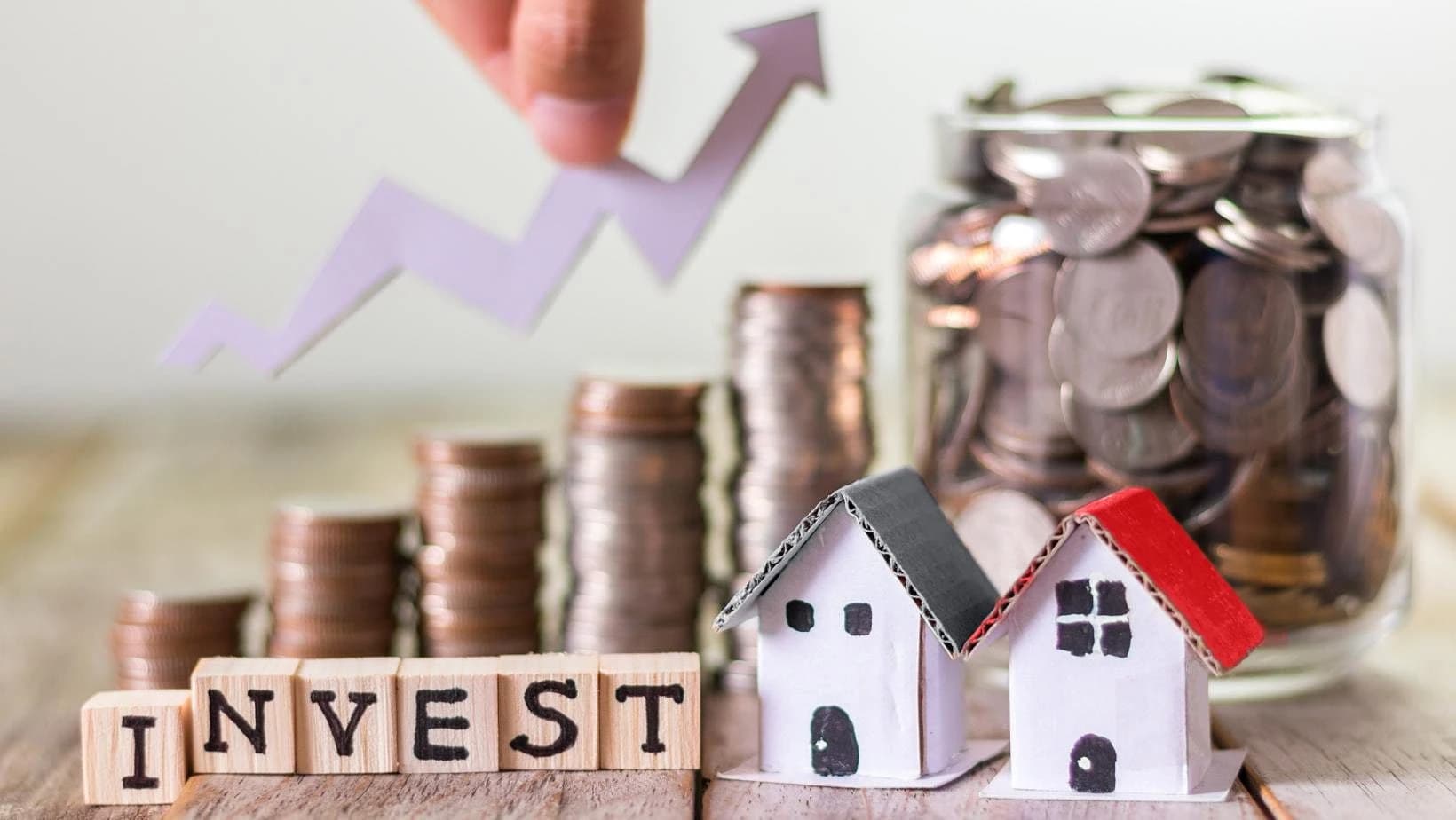 Investment growth with coins, houses, and chart