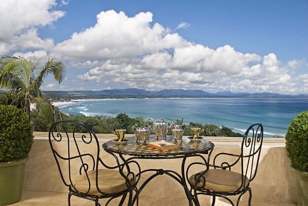 Table and chairs with tea set facing ocean view