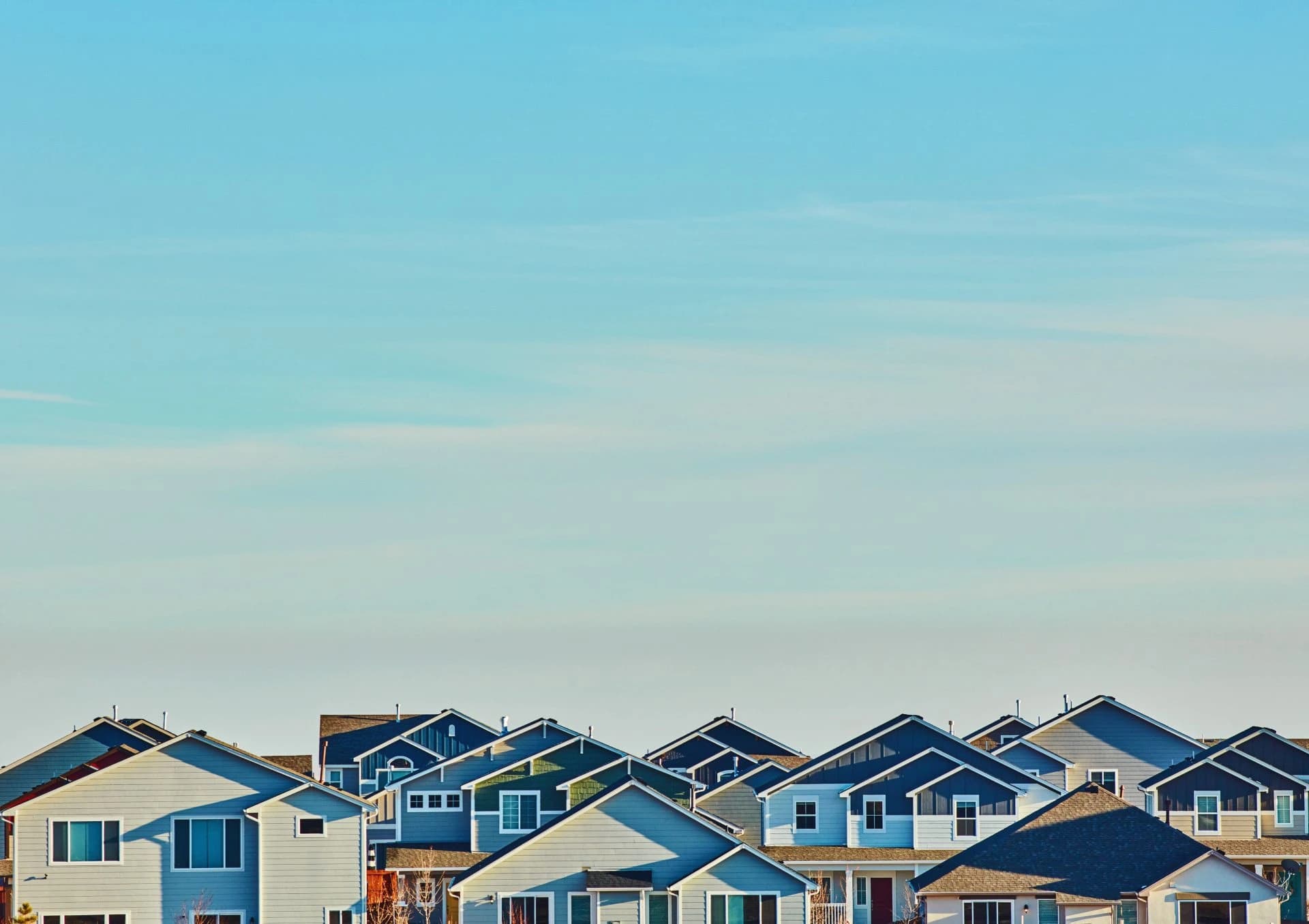 Row of suburban houses under a blue sky