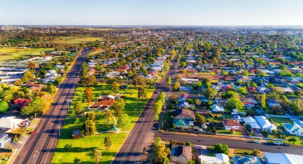 Suburban neighborhood with two roads and many houses.