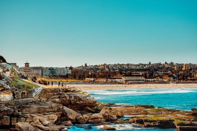Rocky coast meets beach town with blue ocean