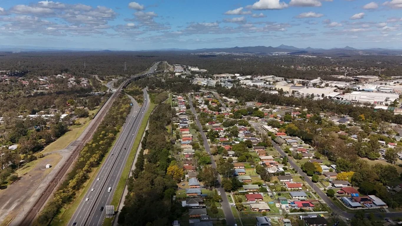 Aerial view of homes and transport corridors in Brisbane western suburbs