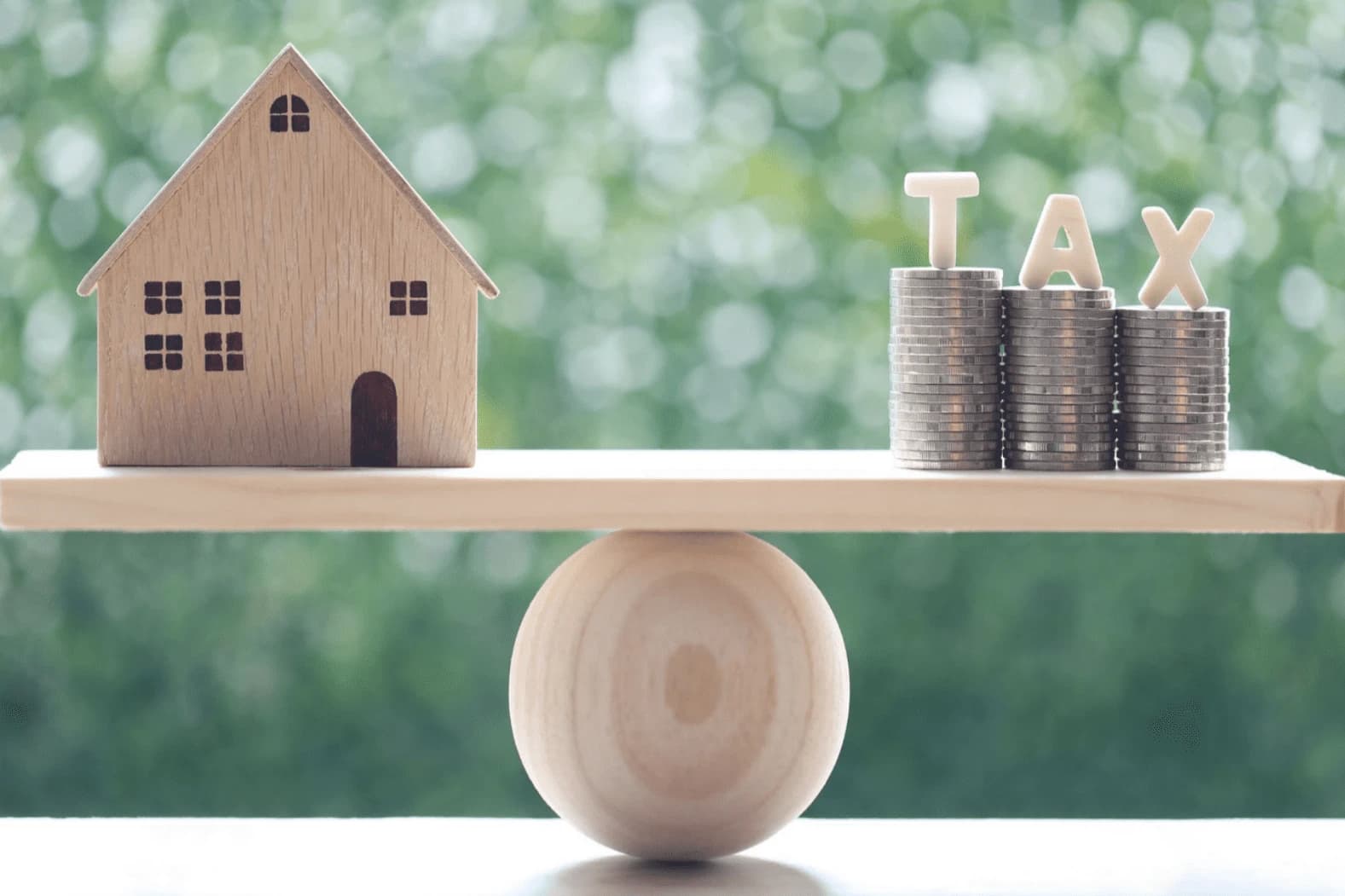 House and coins on a balance scale
