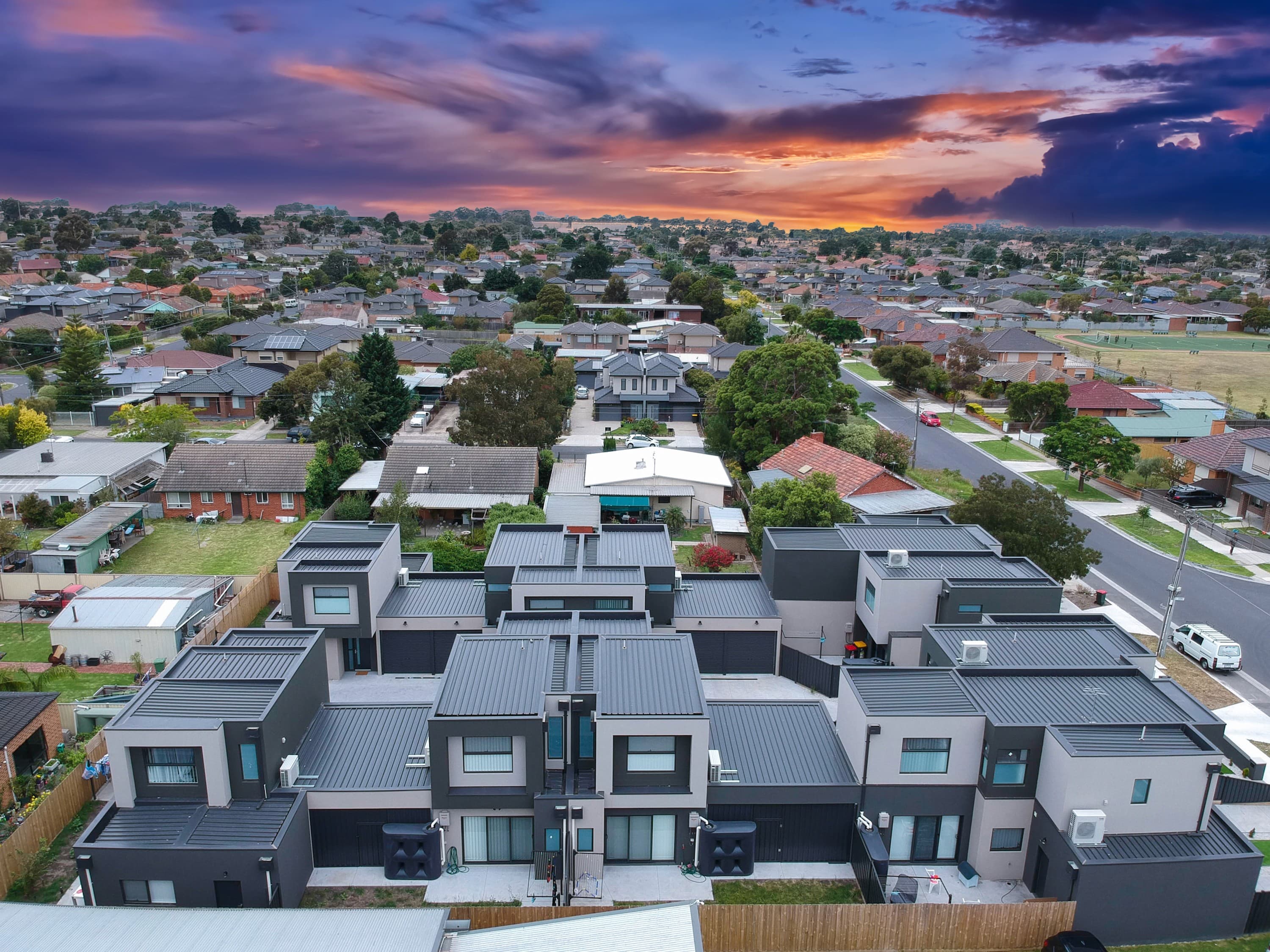 Aerial view of townhouses and detached homes in an Australian suburb at sunset