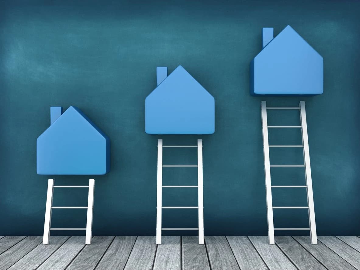 Blue houses on ladders ascending in size.