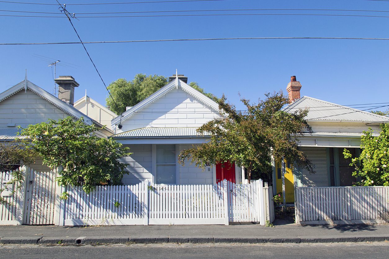 Charming bungalow homes with white picket fence. Image of iStock 985940756
